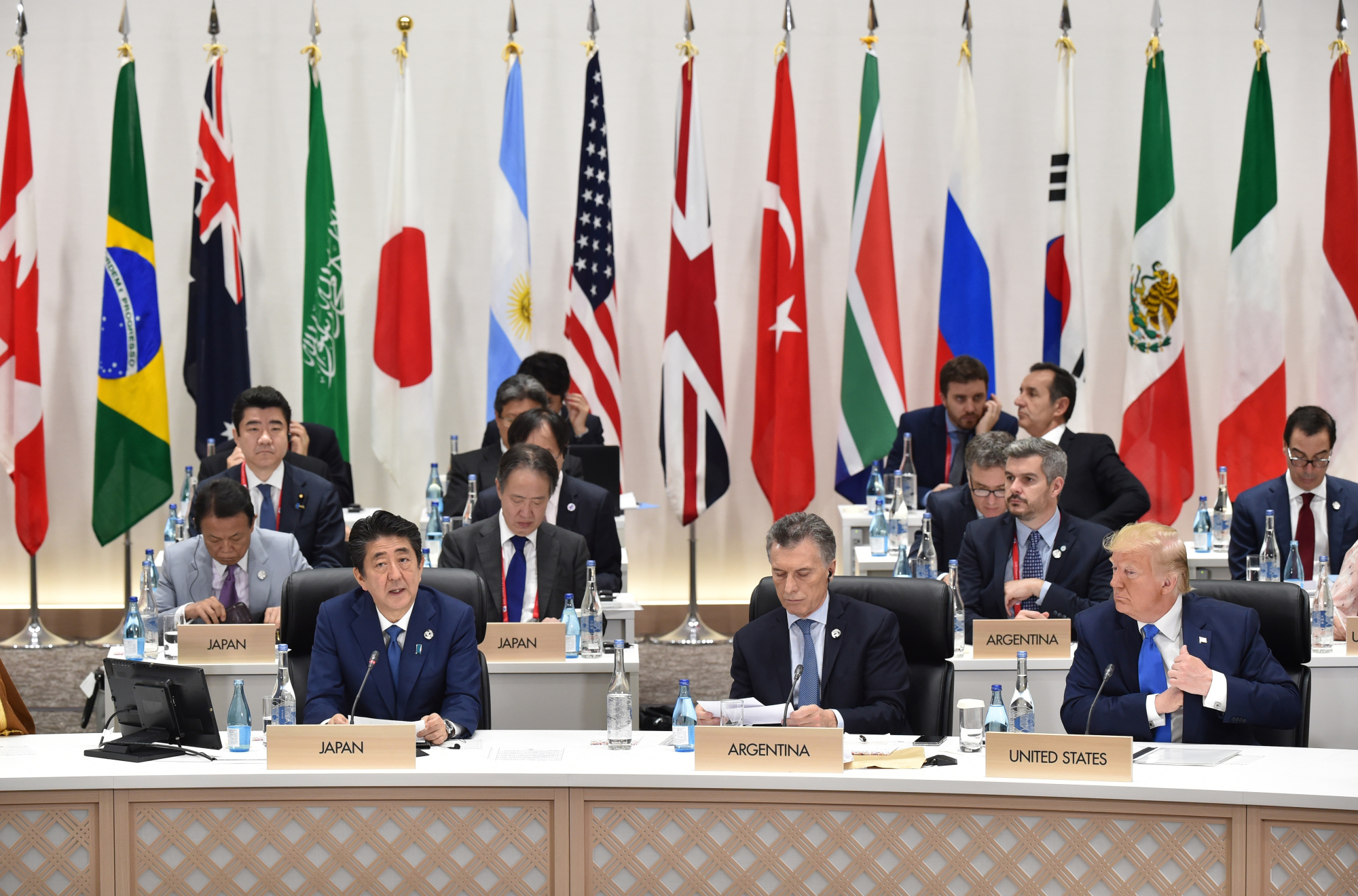 Shinzo Abe, Japan's prime minister, front row left, speaks as Mauricio Macri, Argentina's president, front row center, and U.S. President Donald Trump, front row right, attend a session at the Group of 20 (G-20) summit in Osaka, Japan, on Saturday, June 29, 2019. Disputes over wording on climate change and trade are unresolved shortly before Group of 20 leaders are due to release a communique from their summit in Japan, raising the risk of a very watered-down document or no statement at all. Photographer: Kazuhiro Nogi/Pool via Bloomberg